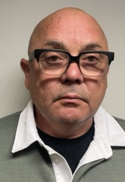 Police booking photo of bald man with glasses