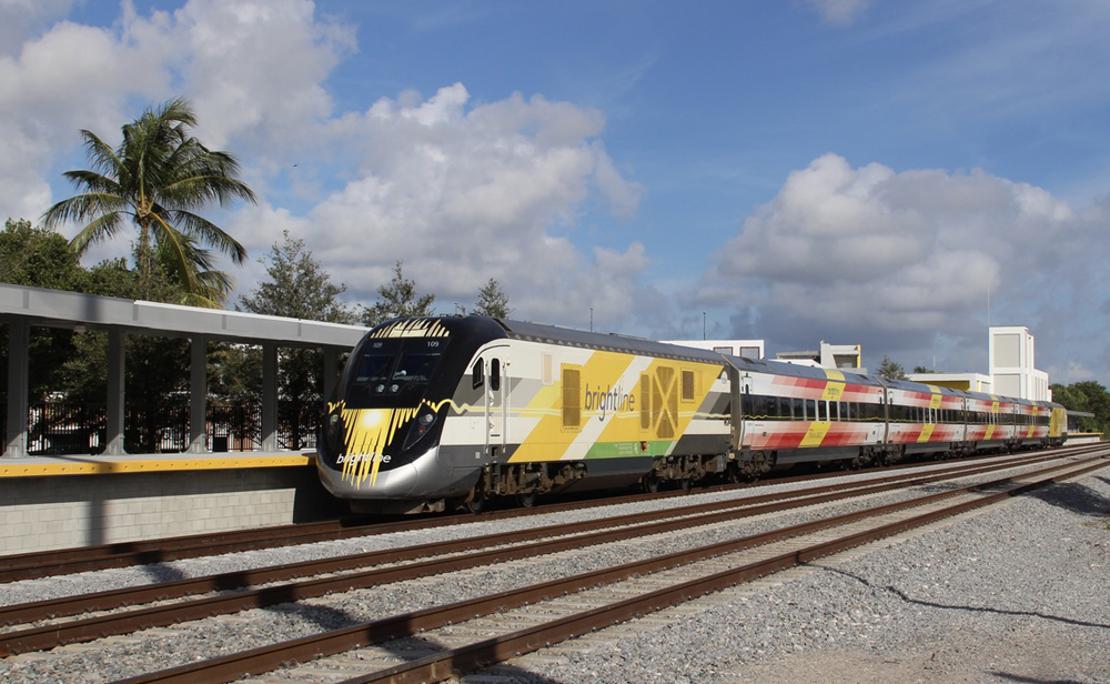 Yellow and white streamlined locomotive at station