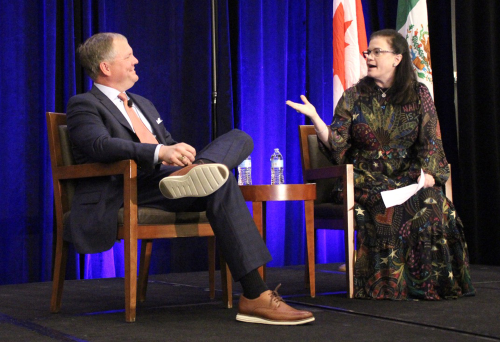 Man and woman talking while seated on stage