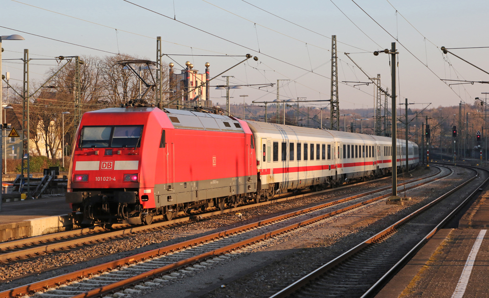 Red electric locomotive with white passenger cars
