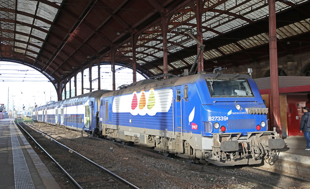 Blue and white electric locomotive with commuter train