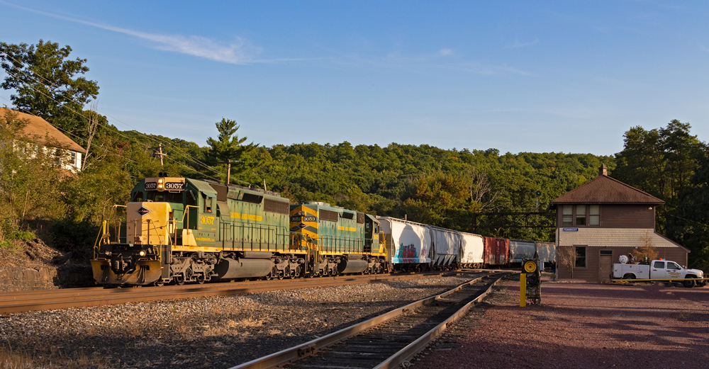 Green and yellow locomotives lead freight train