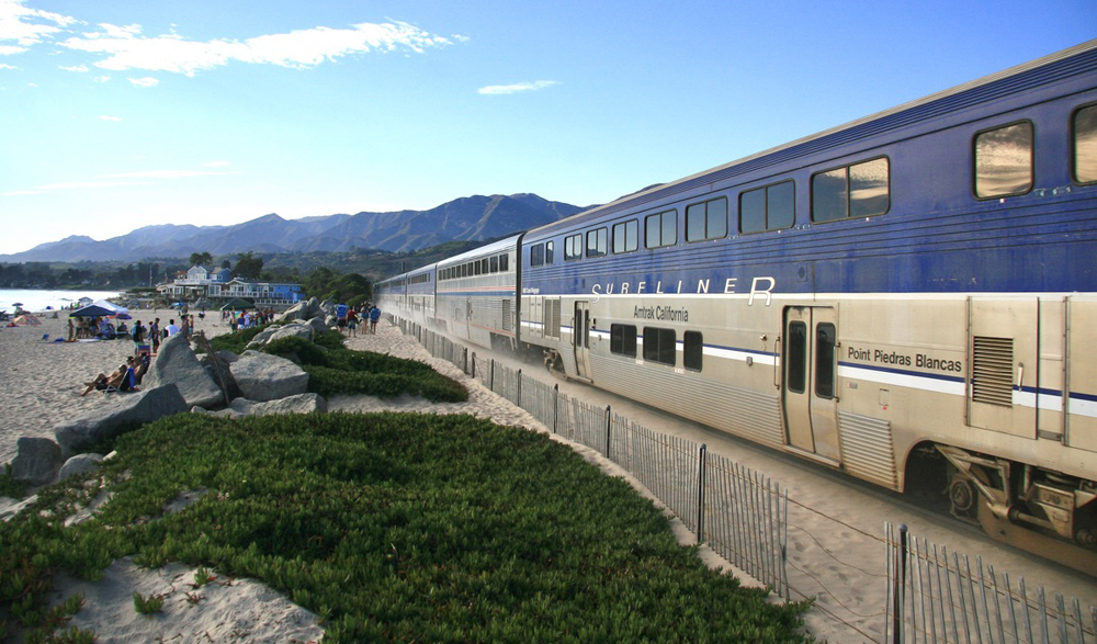 Passenger train running along beach