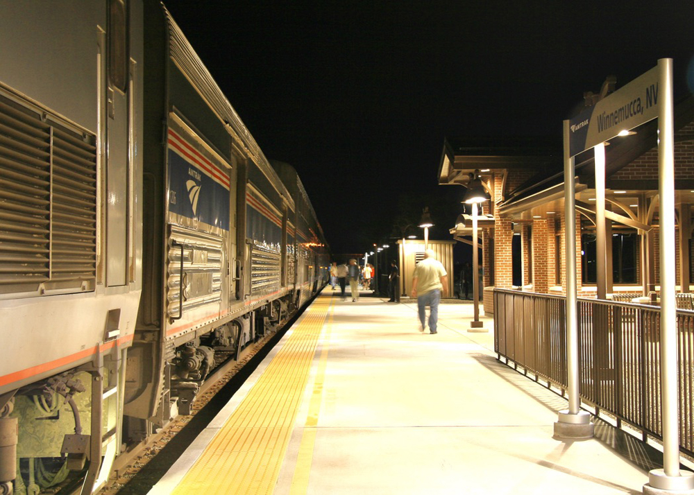 Train stopped at station platform at night