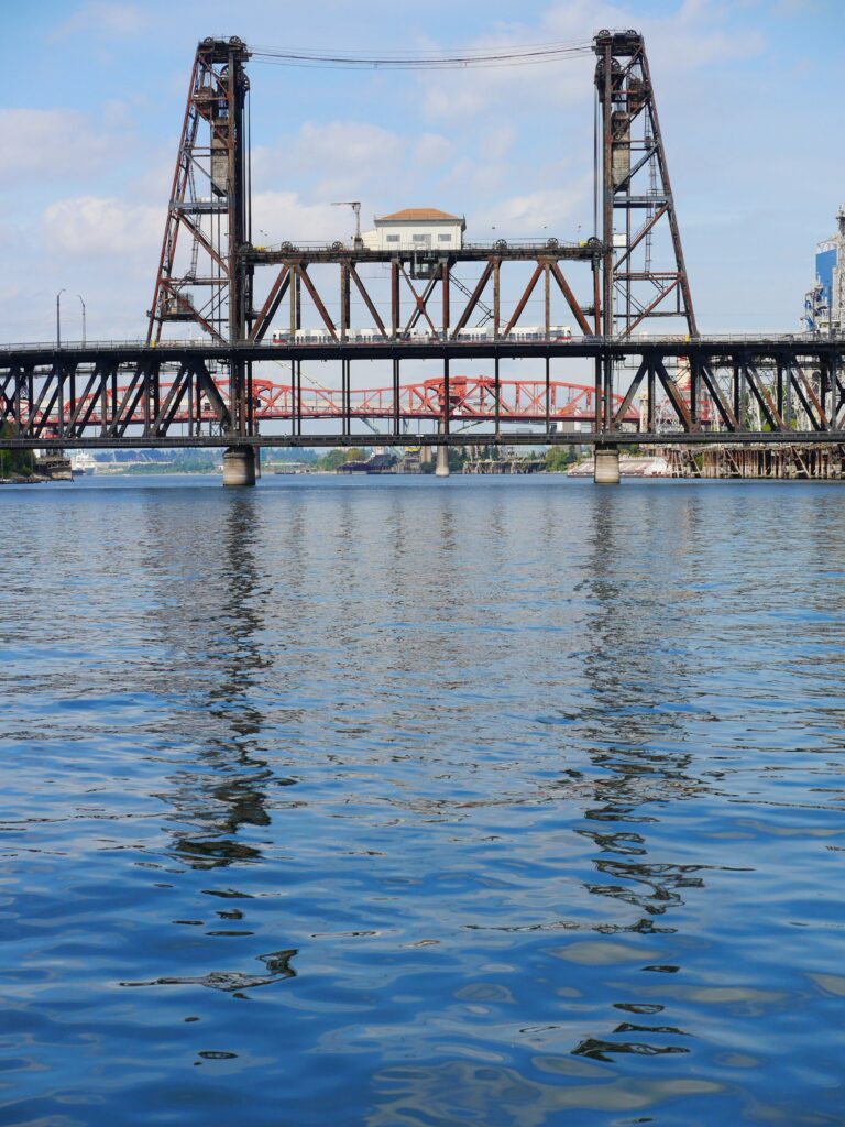 Passenger train traveling over steel double-deck bridge.