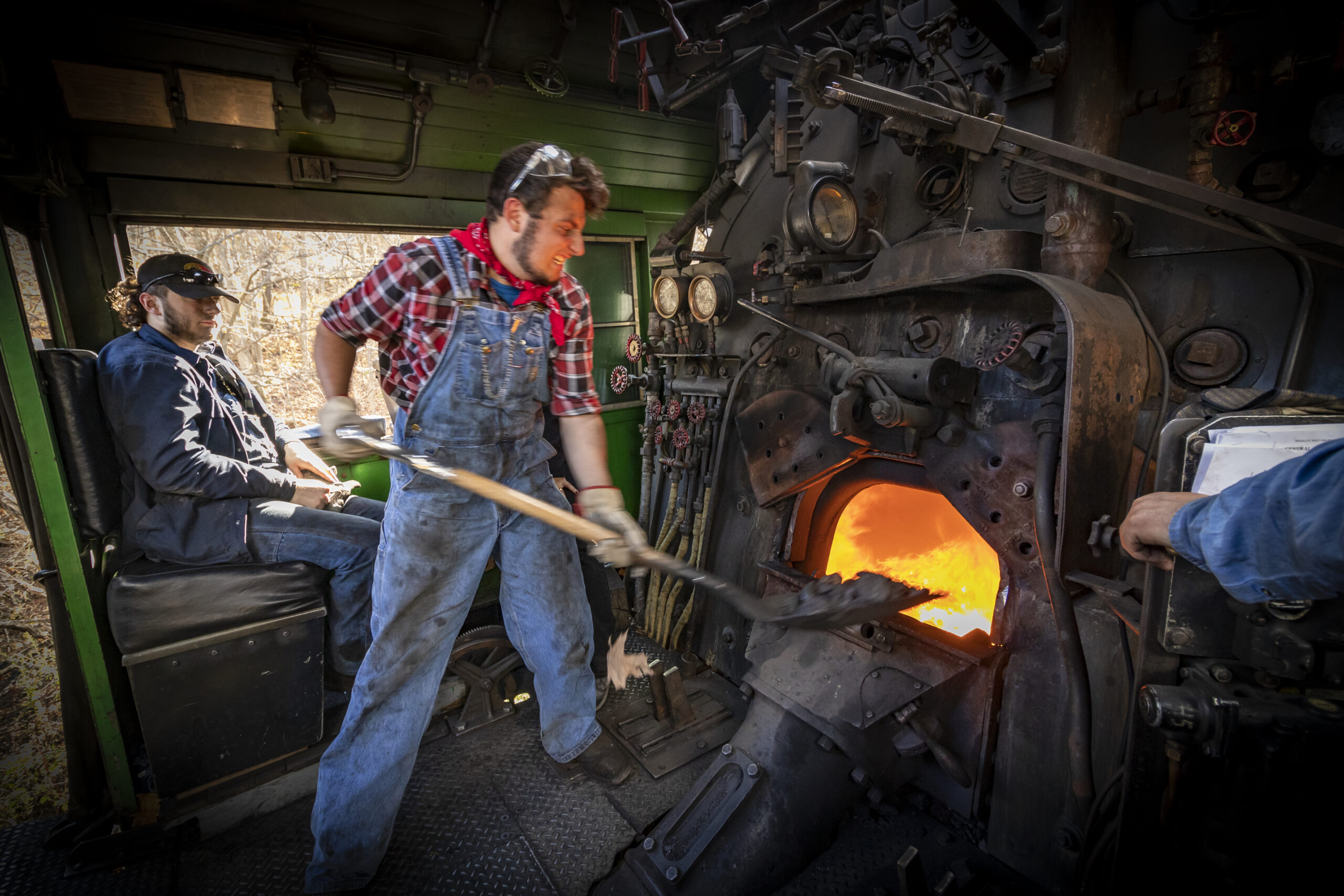 conductor shoveling coal into firebox