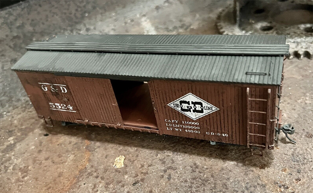 Car Swap Project Part 1: Trading models: heavily weathered model brown boxcar with black roof and white lettering