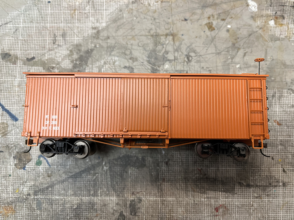 Brand new brown boxcar model laying on its side