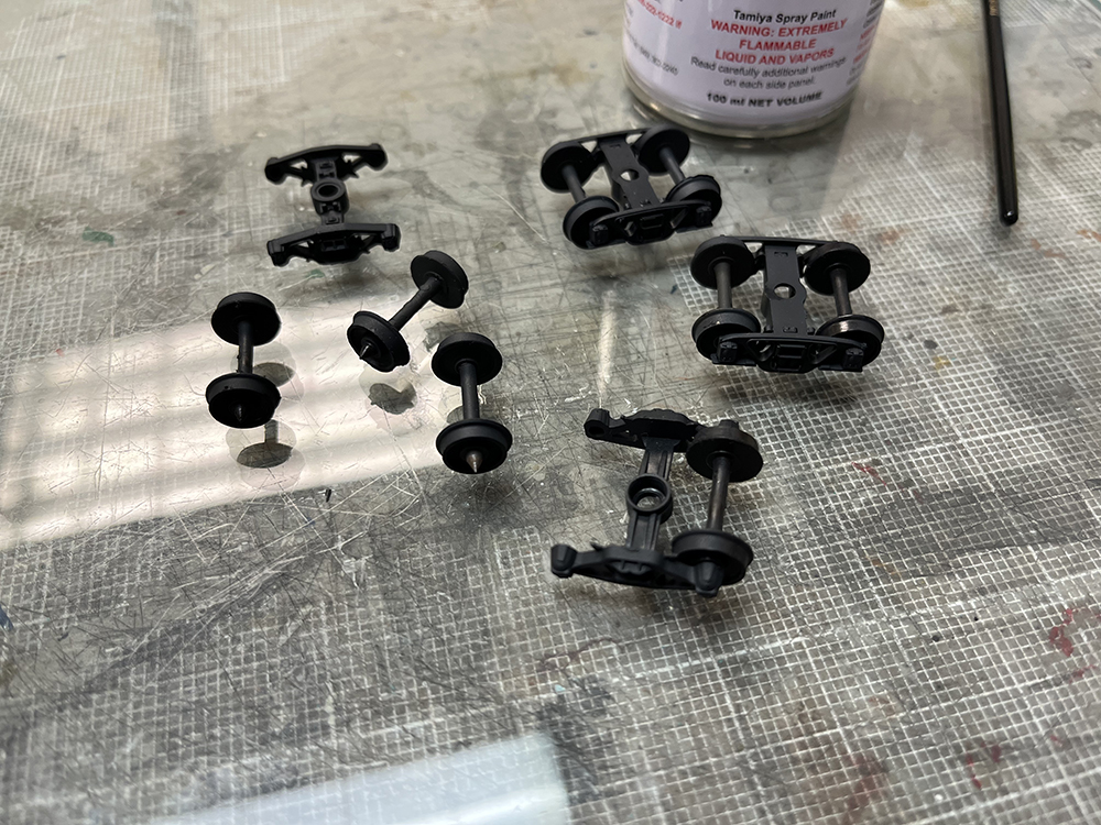 Black plastic wheels on glass-topped counter with assorted black plastic truck frames.