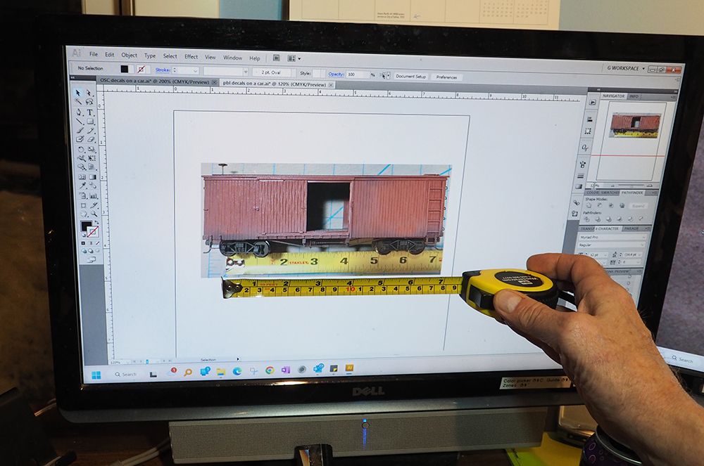 Car Swap Project Part 4: Railroad herald design class: Brown model boxcar photo on computer screen and hand holding yellow tape measure.