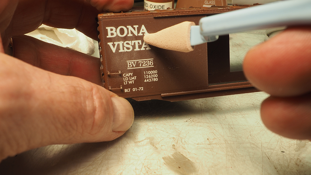 Makeup applicator applying powdered pastel to model boxcar.