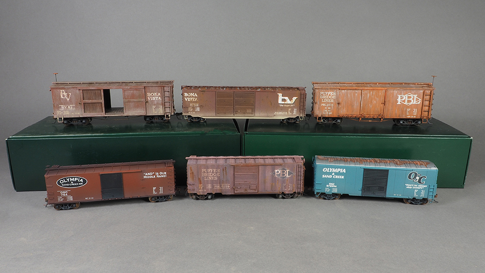 Car Swap Project part 9: Lessons learned: brown and blue plastic model boxcars displayed together on a gray background