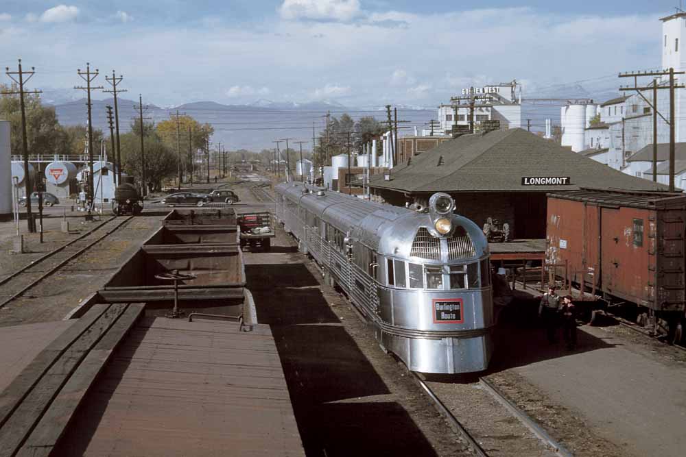 Streamlined Burlington Zephyr 9900 train at station between freight cars