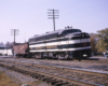Black-and-white Louisville & Nashville diesel locomotive with hopper freight car