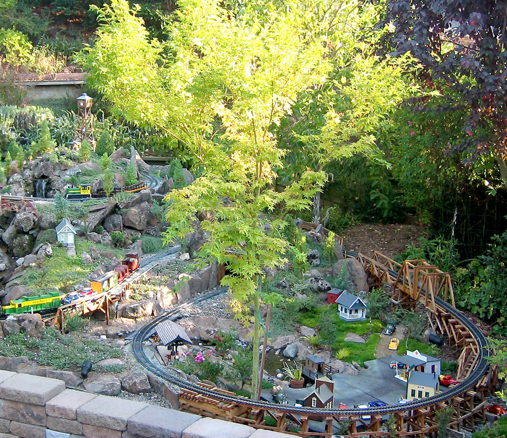 miniature tree with yellow leaves on garden railroad
