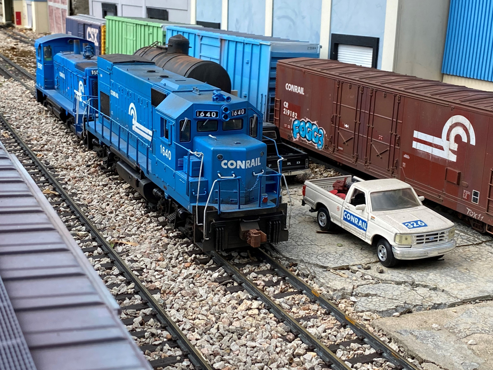 two blue model switch engines on a garden railroad