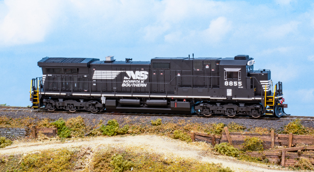 A black HO scale Norfolk Southern diesel model is seen on a scenicked base