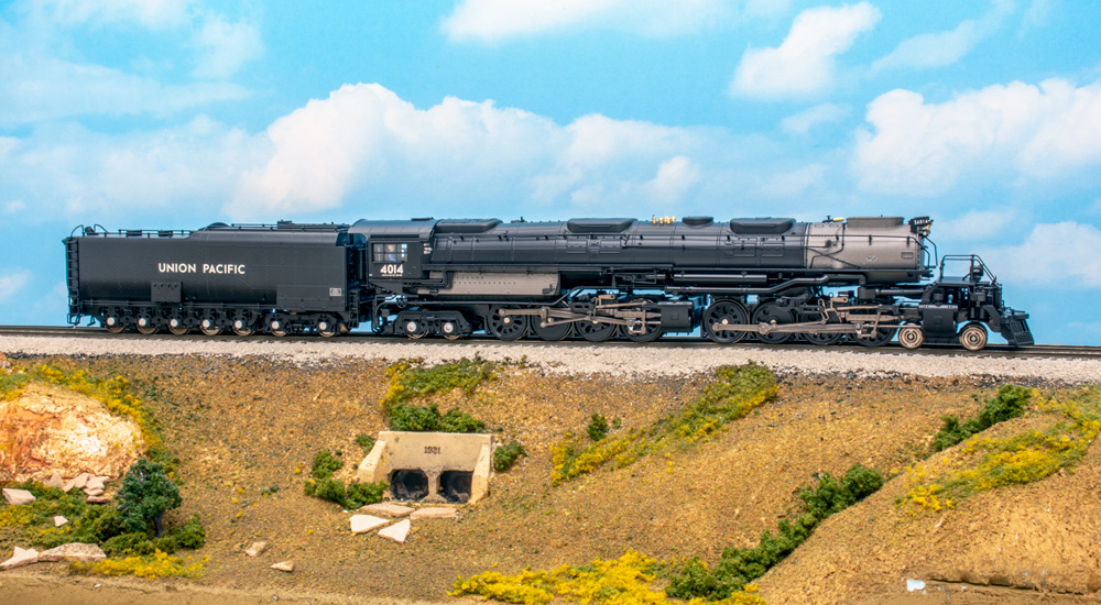 A long, black Union Pacific 4-8-8-4 steam locomotive model on a scenicked base