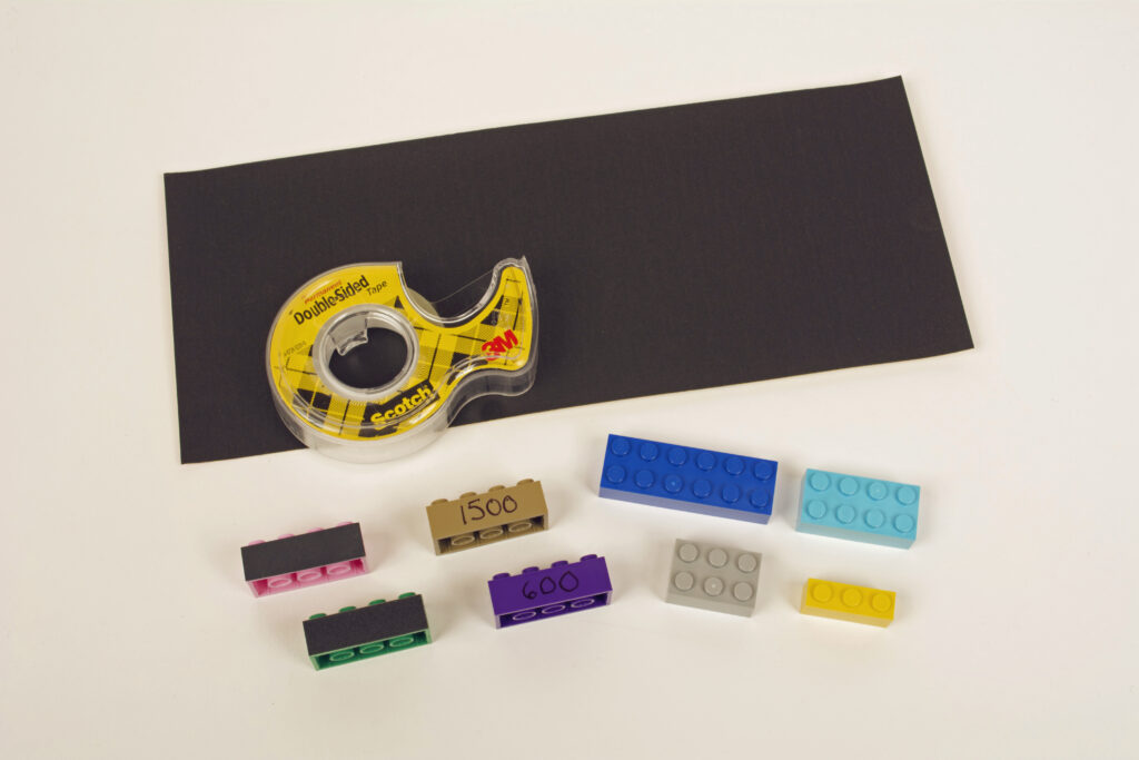 Photo showing sandpaper, double-sided tape, and assorted Lego bricks.