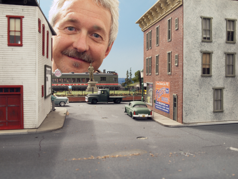 Meet Gerry Leone: man’s face peeking from behind model structure
