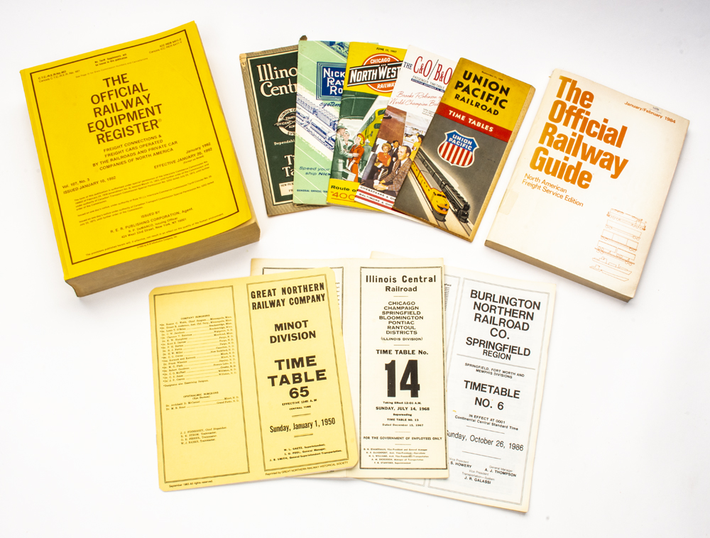 Photo of timetables and railroad publications on white background