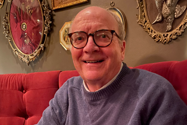 man with glasses on red couch