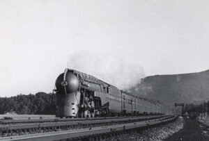 round-nosed, streamline steam locomotive leading train.