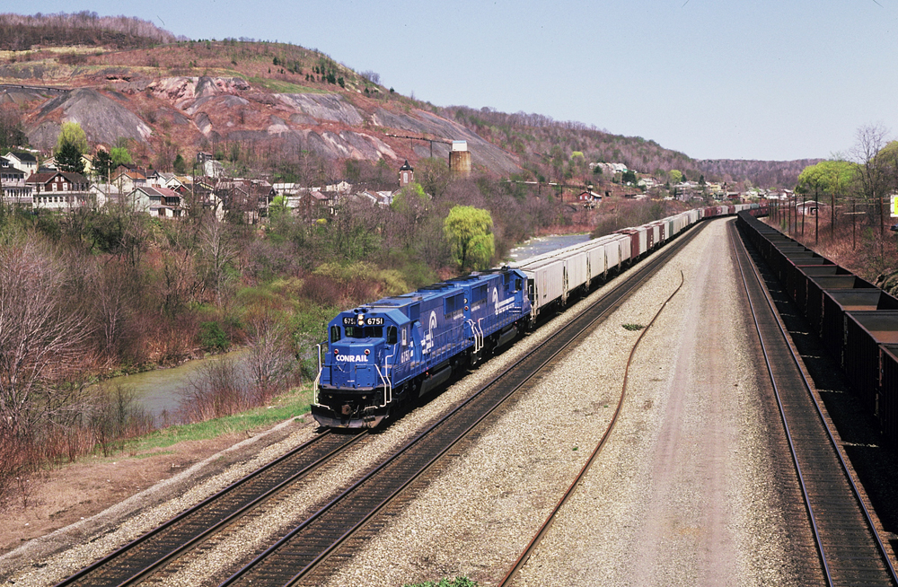 Two blue diesel locomotives pulling a freight train