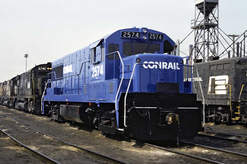 Shiny blue diesel locomotive among dirty black locomotives