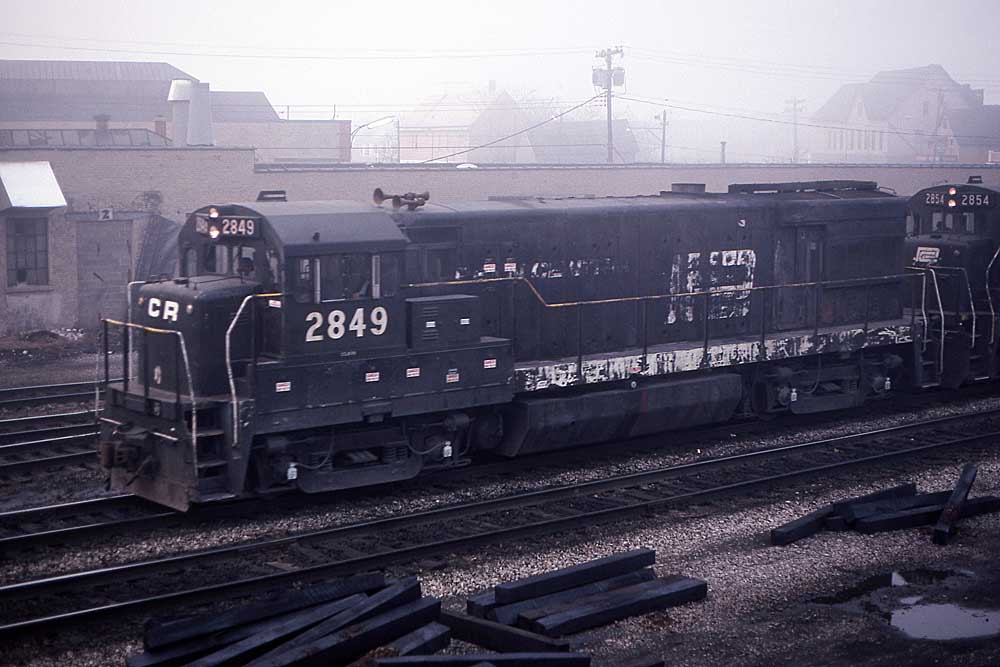 Black-and-white diesel locomotive leading train in fog