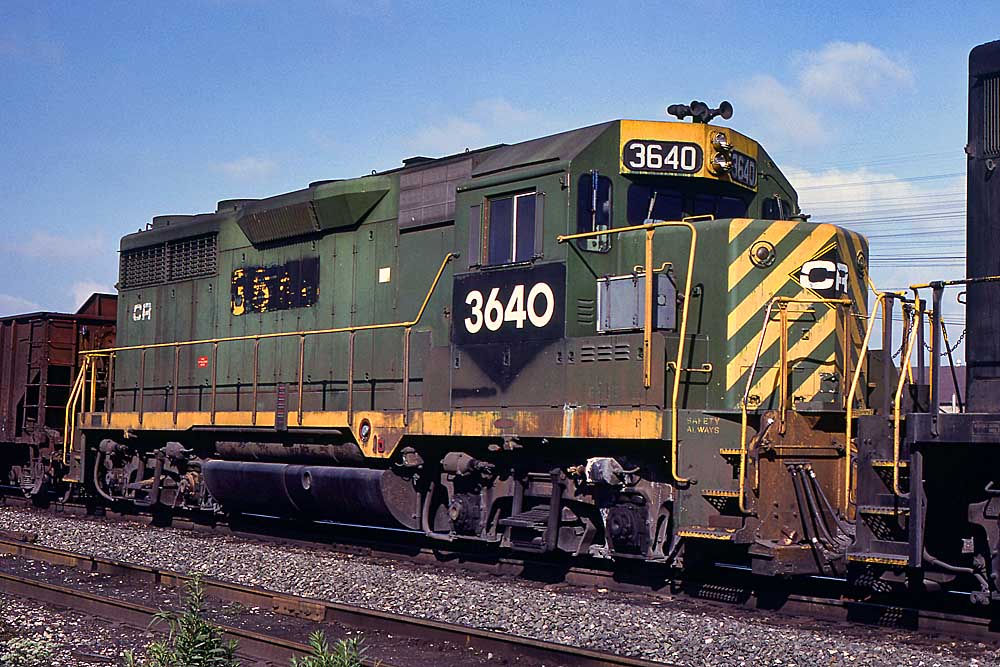 green-and-yellow diesel locomotive on freight train