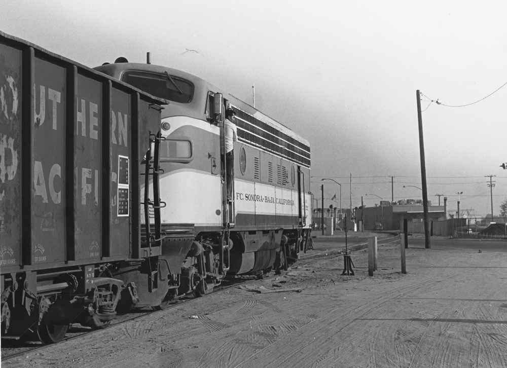 black and white photo crew pulling train back from the border