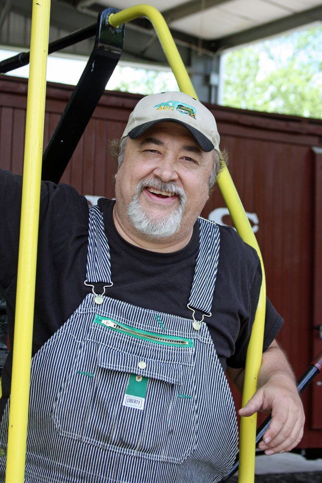 Man in overalls on steps of railroad car