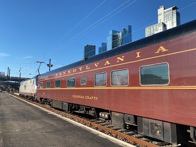 Three-quarters view of Tuscan red passenger car with gold trim and lettering