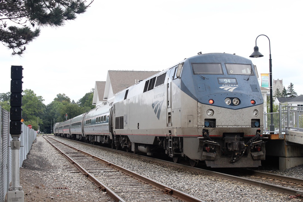 Passenger train at station under cloudy skies