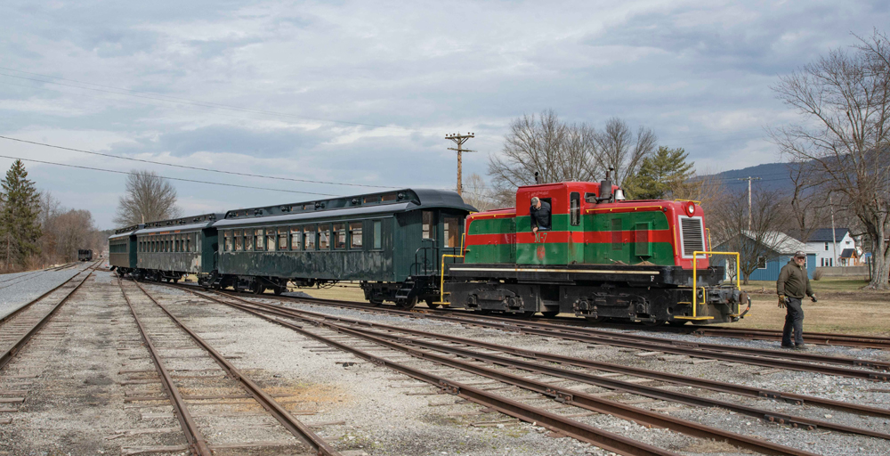 Diesel with three dark green passsenger cars