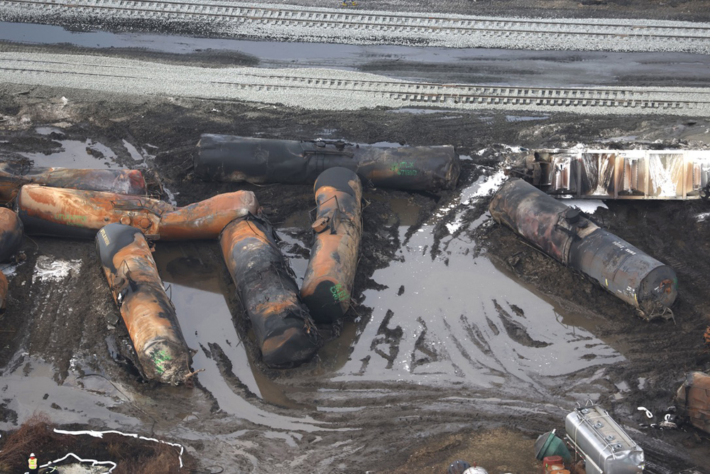 Burned out tank cars and standing water around derailment site