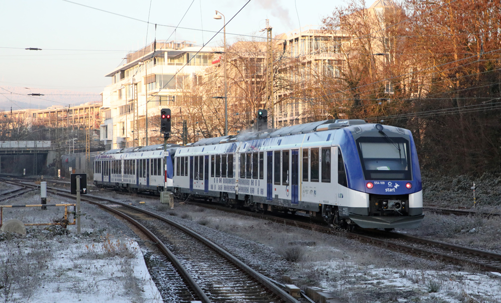 White and blue hydrogen-powered multiple-unit passenger train runs on double-track main