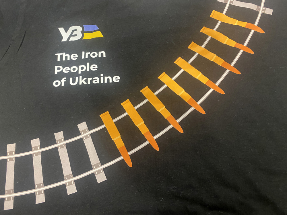 T shirt with "Iron People" slogan and railroad track with some ties replaced by bullets