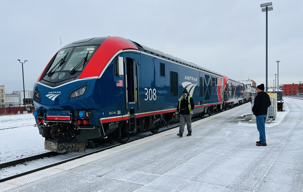 Blue and red passenger locomotives at snowy station platform