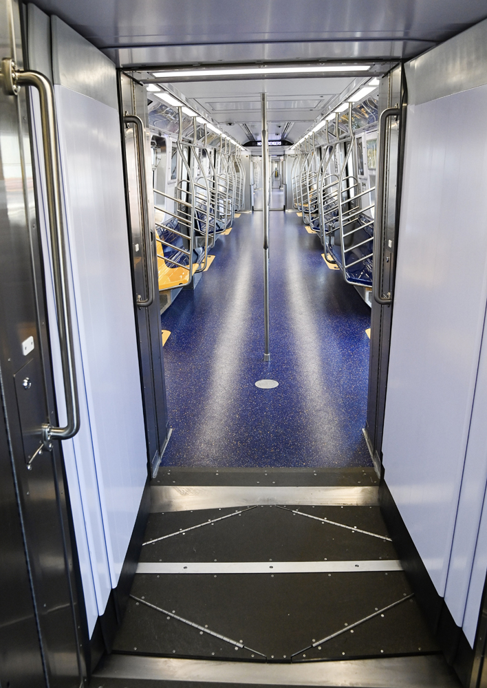 View from one subway car to another through open gangway where most cars have a door