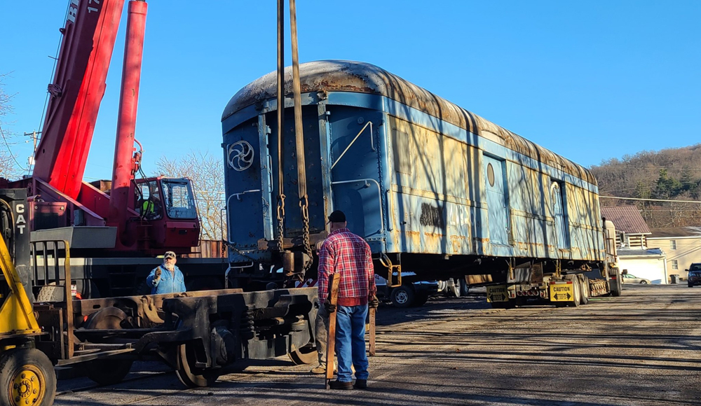 Maintenance-of-way car is lifted by crane for move by truck