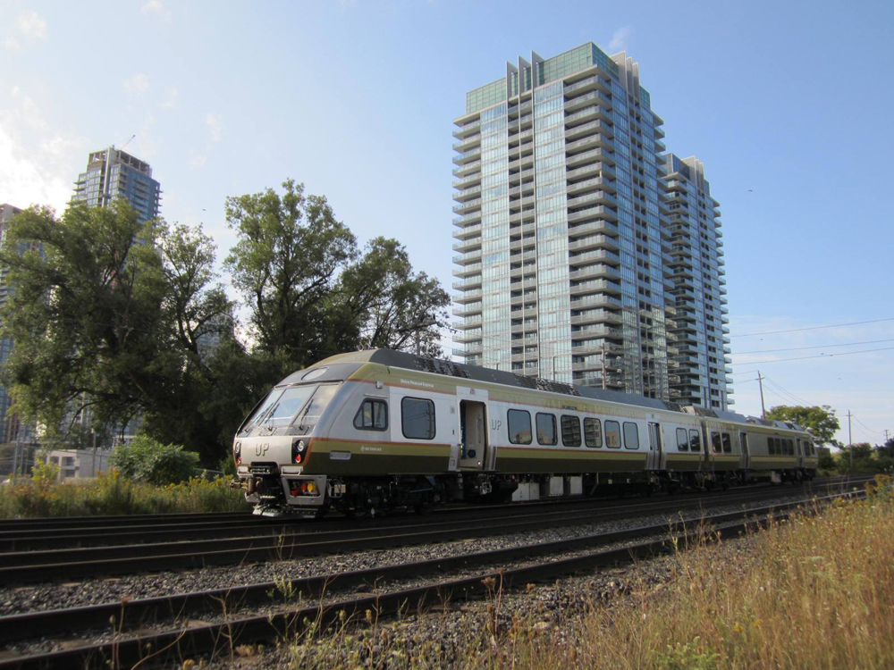 Two-car diesel multiple-unit trainset passes high-rise building