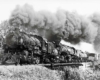 Three quarter view of steam-powered Kansas City Southern locomotives with freight train