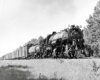 Three quarter view of steam-powered Kansas City Southern locomotives with freight train