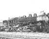 Three quarter front view of steam locomotive in yard