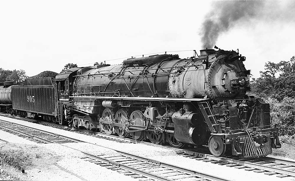 Three quarter front view of steam locomotive in yard
