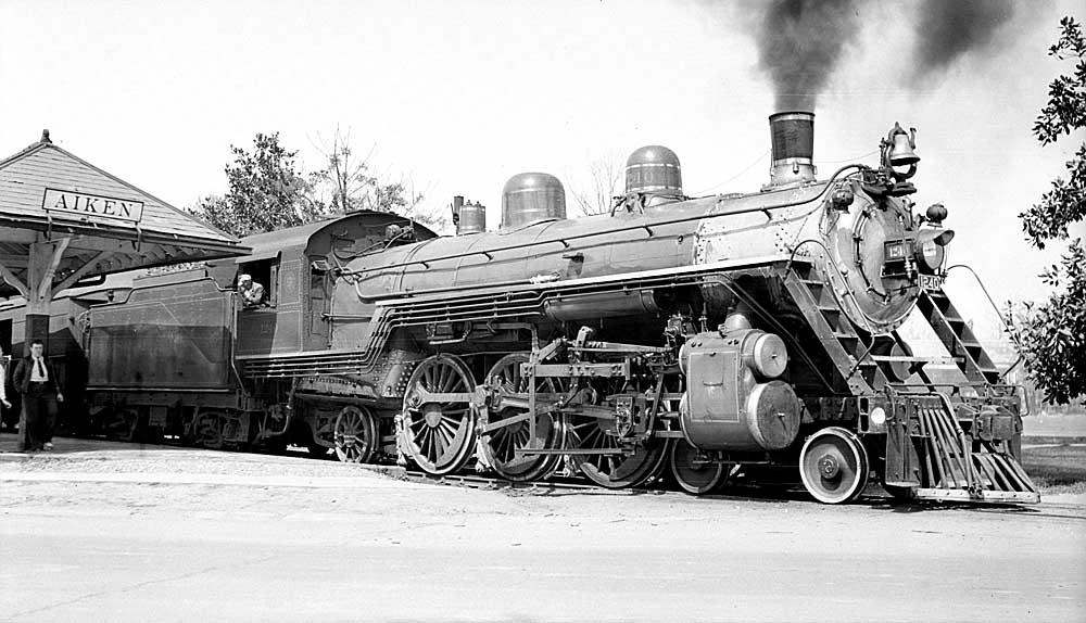 Steam locomotive outside passenger train station