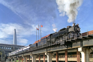 Steam locomotive operating through a city.