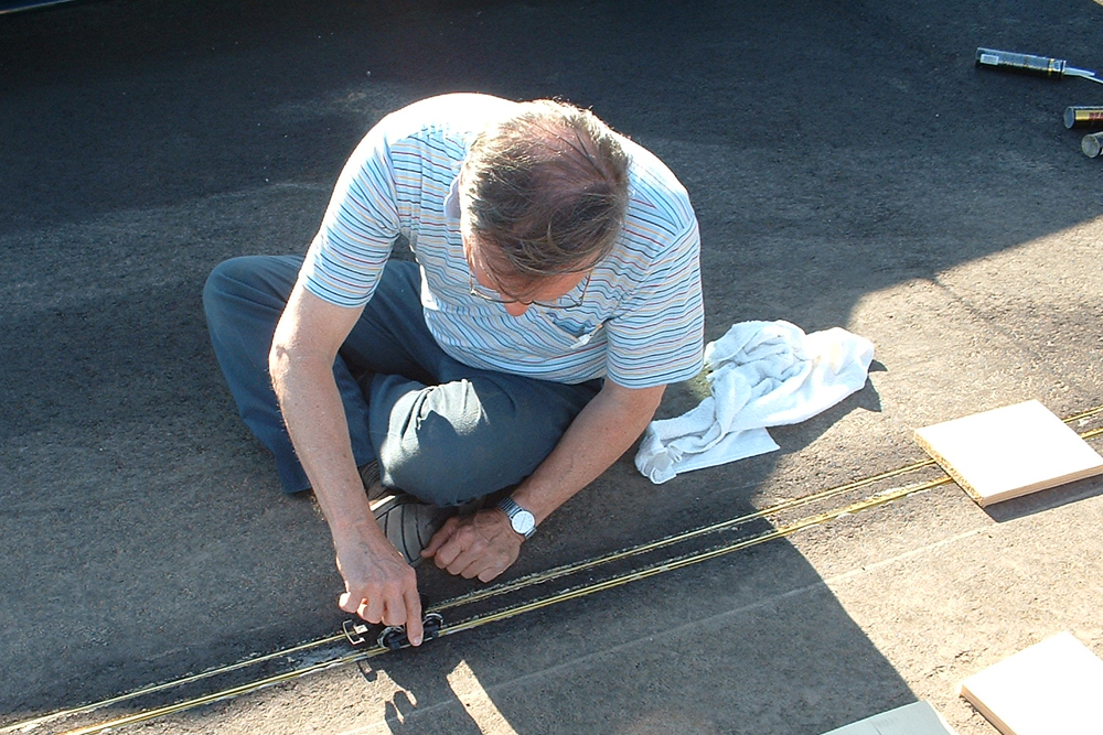 man holding pair of trucks on gauge-1 track